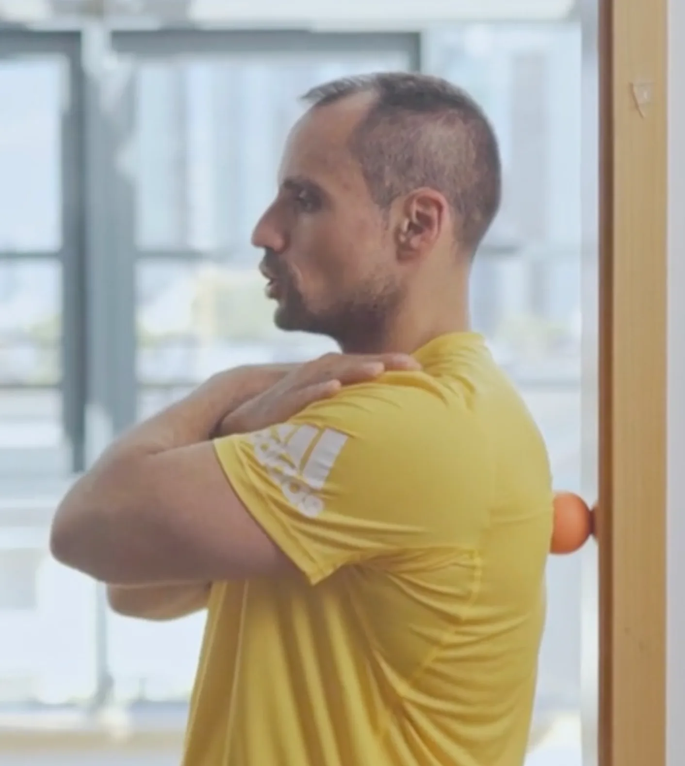 Man releasing shoulder tension with a massage ball