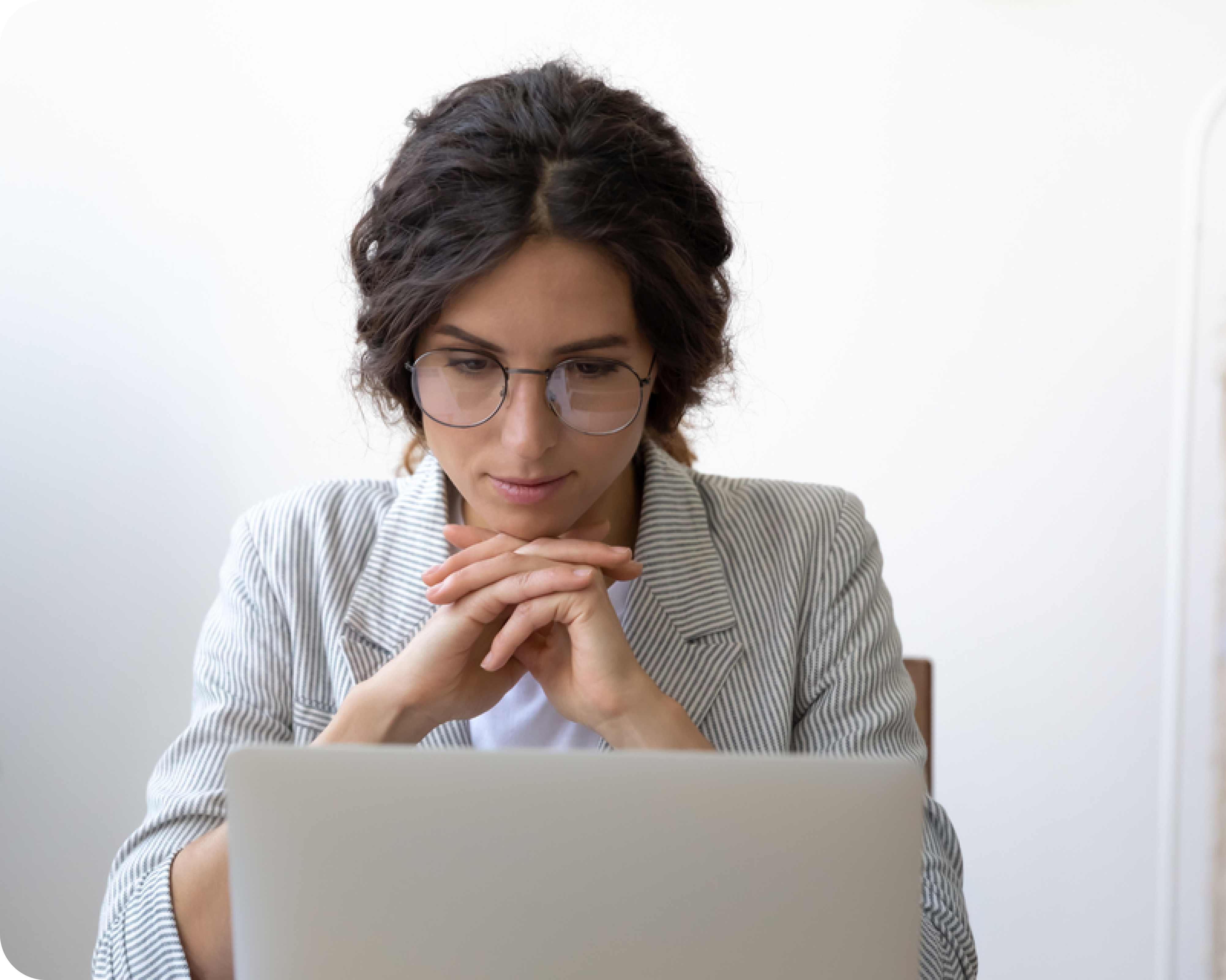 Eine Frau sitzt konzentriert vor ihrem Laptop