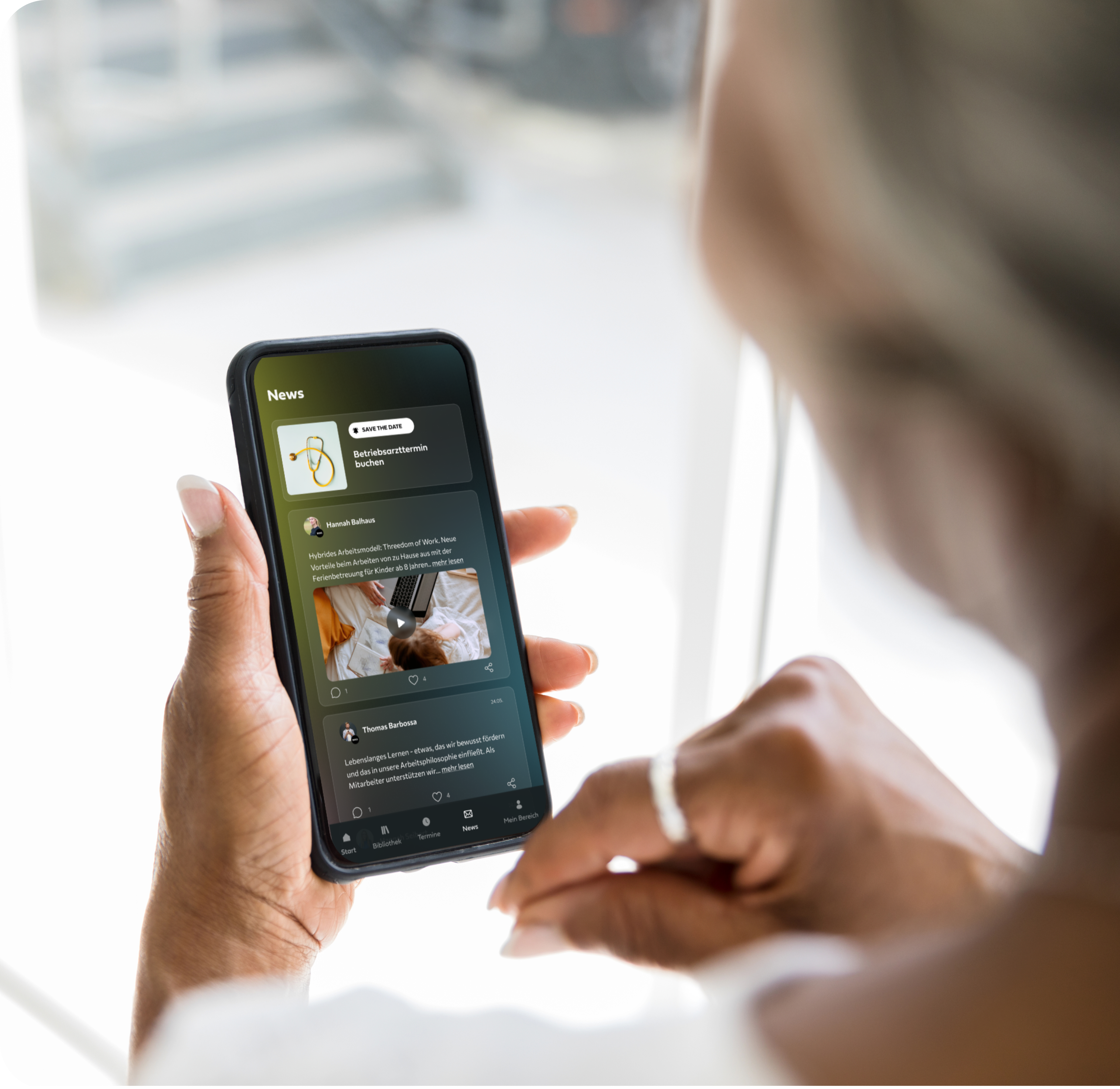 Eine Frau liest den firmeninternen Newsfeed in der Mindance App